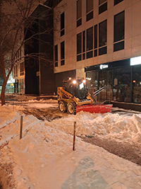 Bobcat hóeltakarítás éjszaka parkolóban